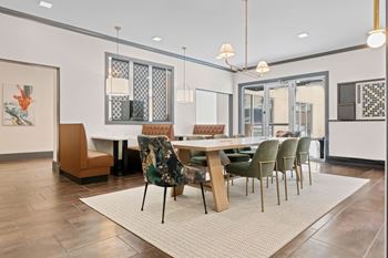 A dining room with a table surrounded by chairs